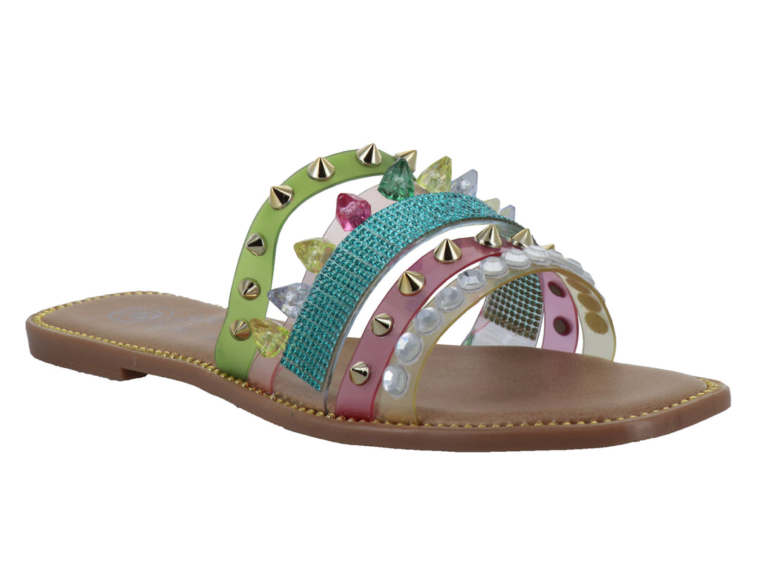 Sandalia plana multicolor con tiras decoradas con tachuelas doradas y gemas brillantes sobre suela café.