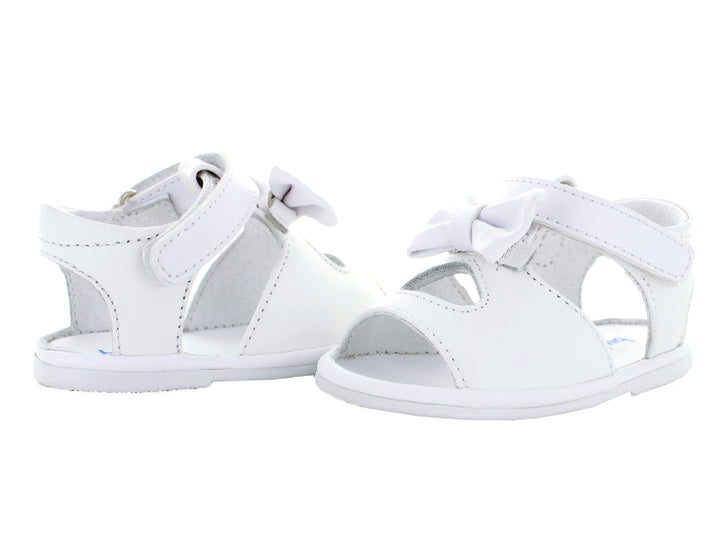 Par de sandalias blancas para bebé con moño decorativo y correa ajustable.