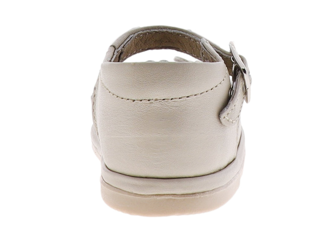 Zapato para bebé color hueso con moño frontal y correa con hebilla metálica.