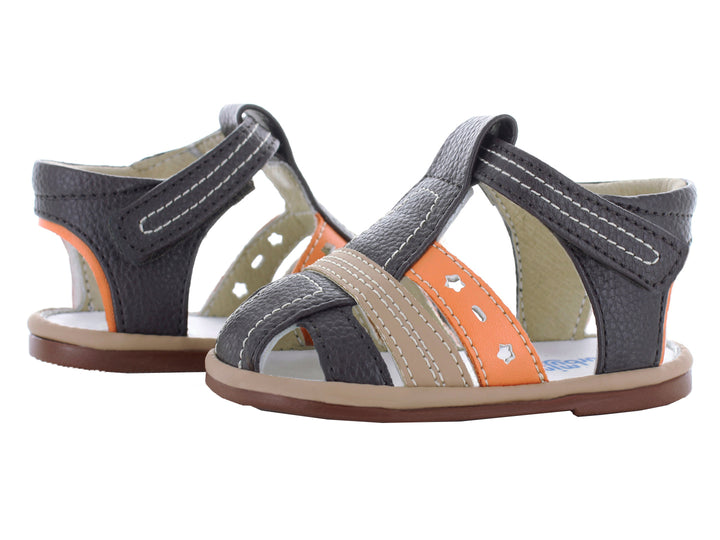 Par de sandalias infantiles color chocolate con detalles en naranja y beige, cierre de velcro y suela café.