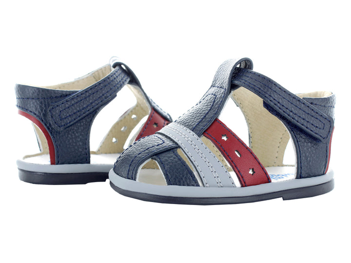 Sandalias infantiles color azul marino con tiras en gris y rojo.