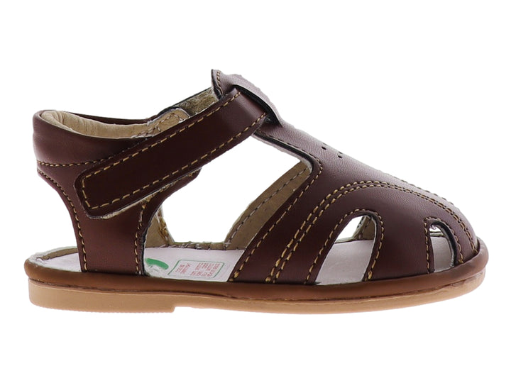 Sandalia infantil color marrón taupe con punta cerrada y correa de ajuste con velcro.