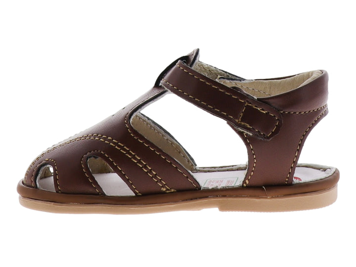 Sandalia infantil color marrón taupe con punta cerrada y correa de ajuste con velcro.