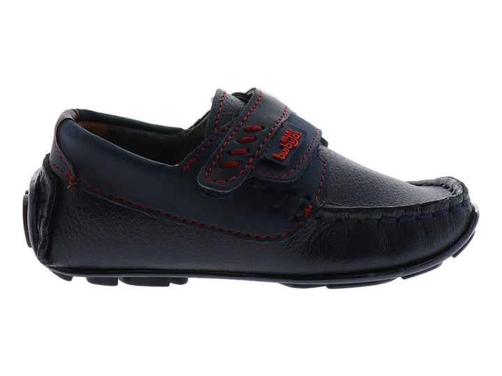Zapato tipo mocasín color azul marino para niño con costuras decorativas en rojo y cierre de correa con velcro.