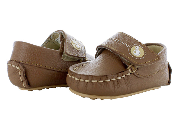Par de mocasines color camel para bebé con correa de ajuste y costuras decorativas en color beige.