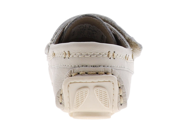 Zapato tipo mocasín para bebé en color hueso con correa de ajuste y costuras decorativas.