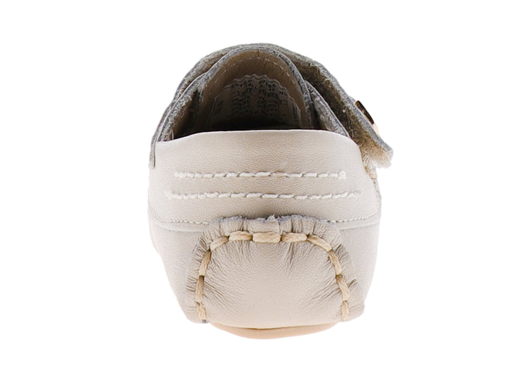 Zapato tipo mocasín para bebé en color hueso con correa ajustable y detalle metálico dorado.