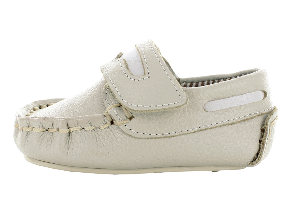 Par de zapatos mocasines color oro para bebé con cierre de correa y costuras decorativas.