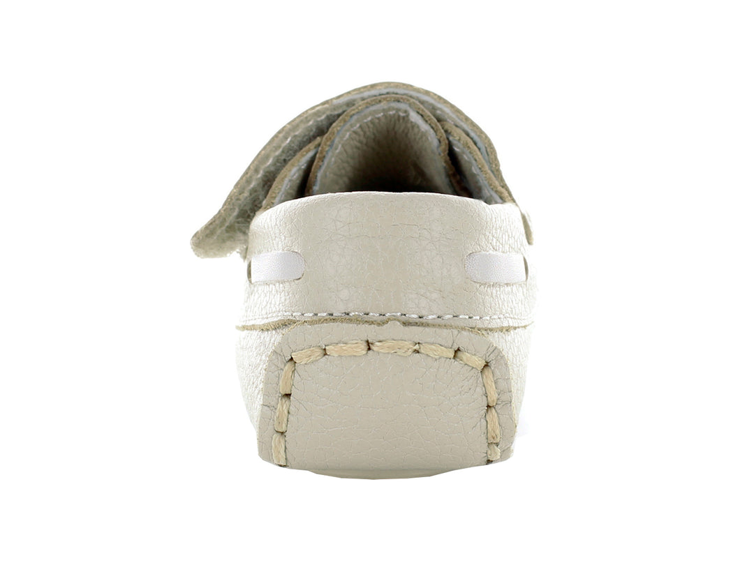 Par de zapatos mocasines color oro para bebé con cierre de correa y costuras decorativas.