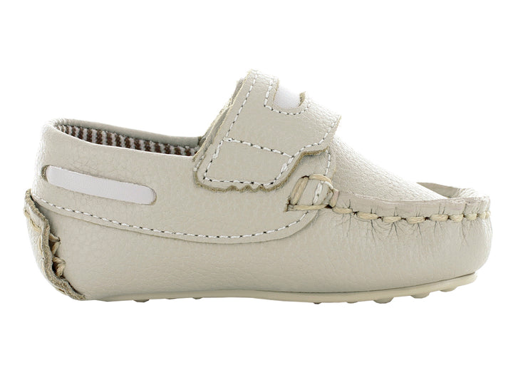 Par de zapatos mocasines color oro para bebé con cierre de correa y costuras decorativas.
