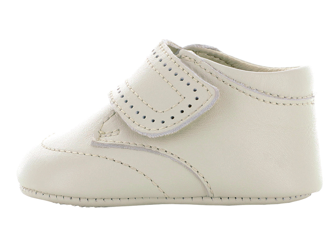 Par de zapatos para bebé color hueso con correa ajustable y detalles perforados.