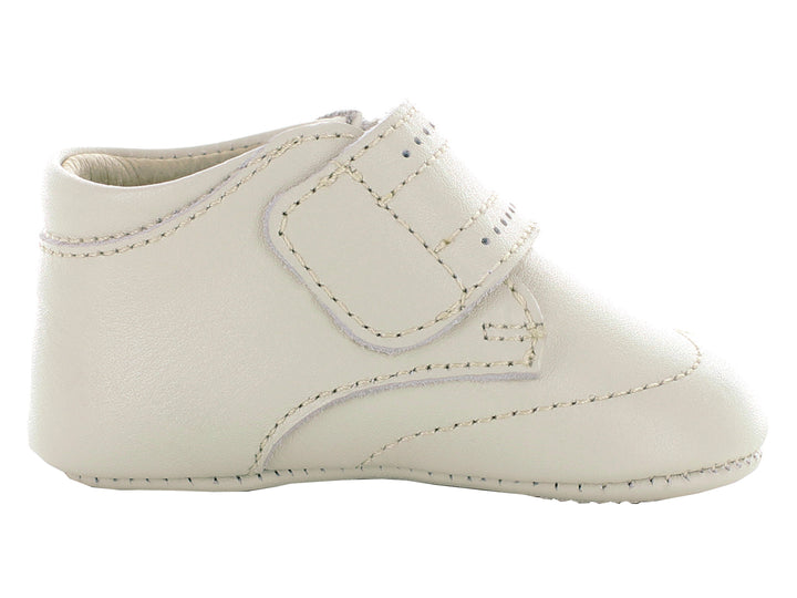 Par de zapatos para bebé color hueso con correa ajustable y detalles perforados.