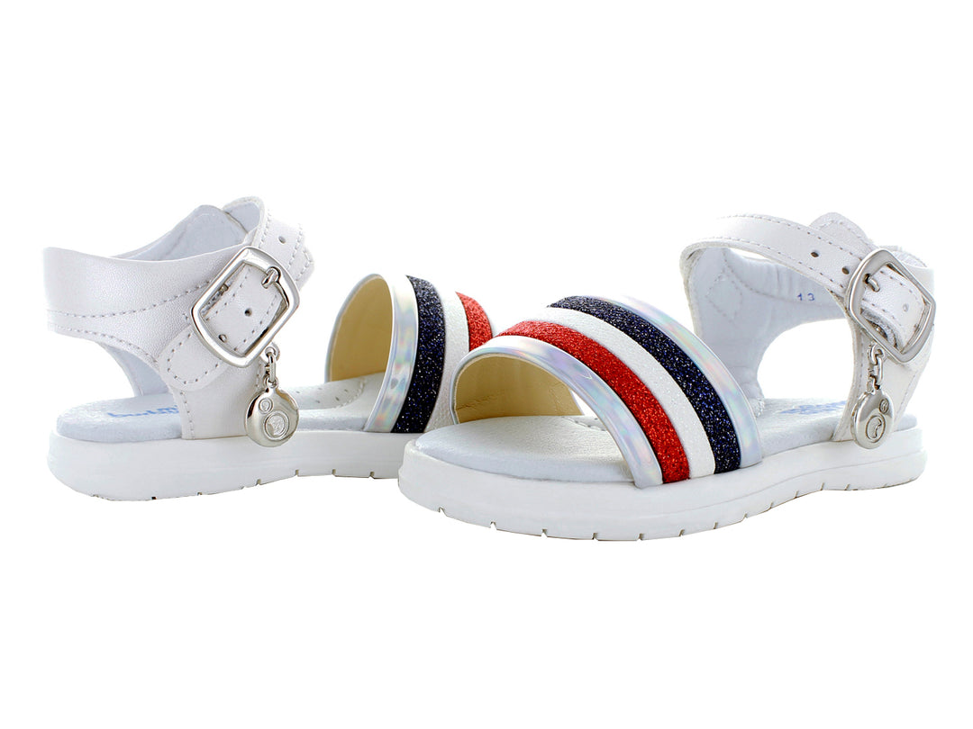 Sandalias blancas para niña con franjas rojas y azules y hebillas plateadas.