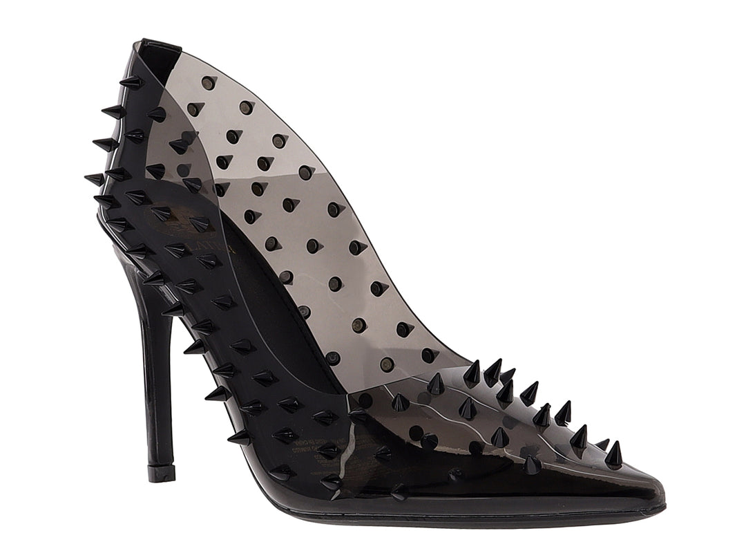 Zapatilla de tacón alto color negro transparente con tachuelas puntiagudas.