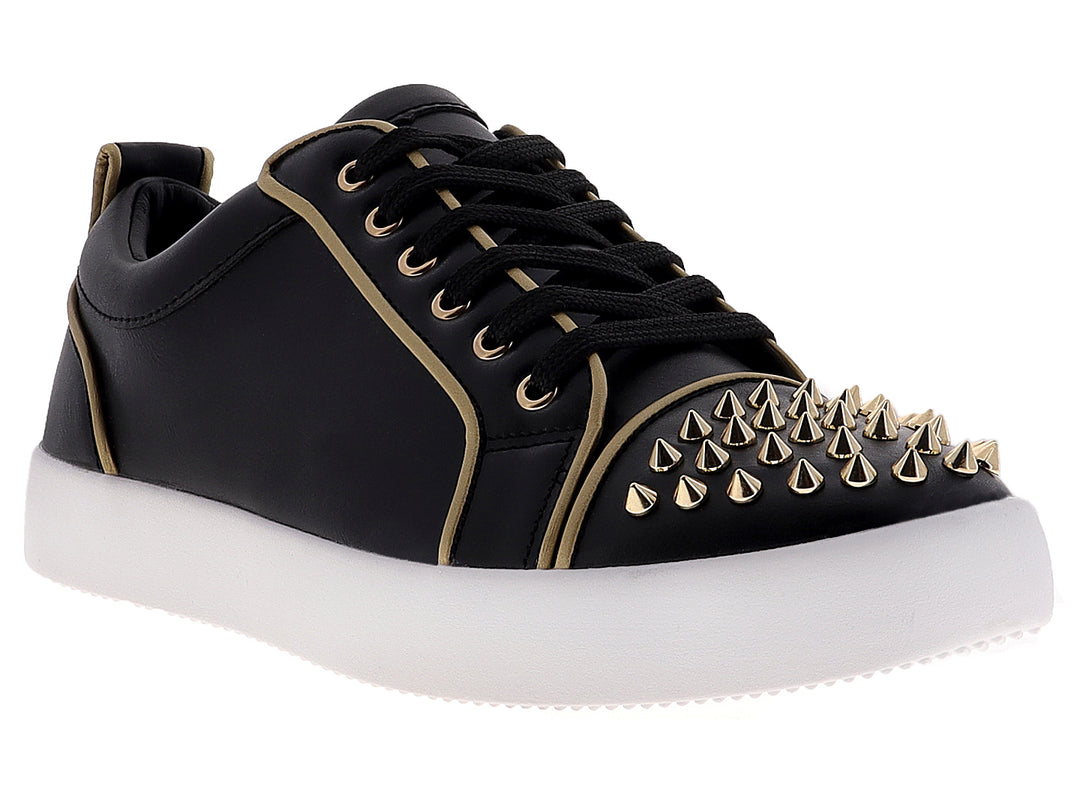 Tenis negros para hombre con tachuelas doradas en la punta y suela blanca.