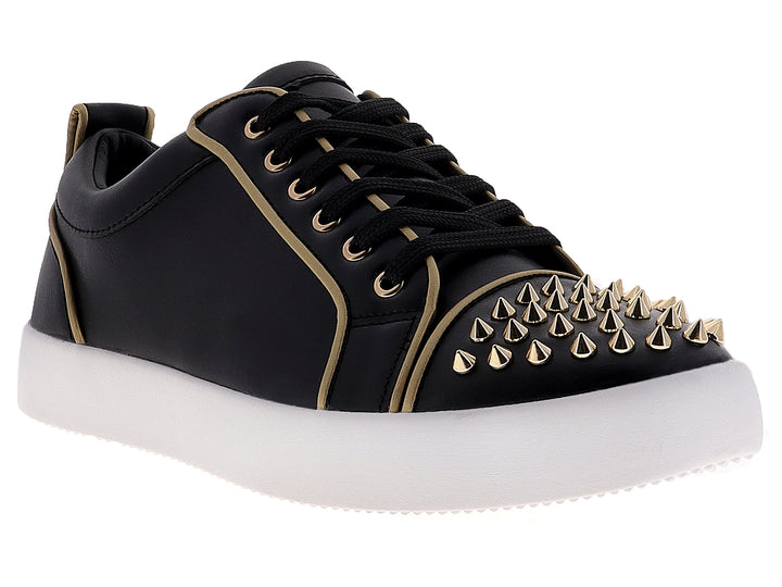 Tenis negros para hombre con tachuelas doradas en la punta y suela blanca.