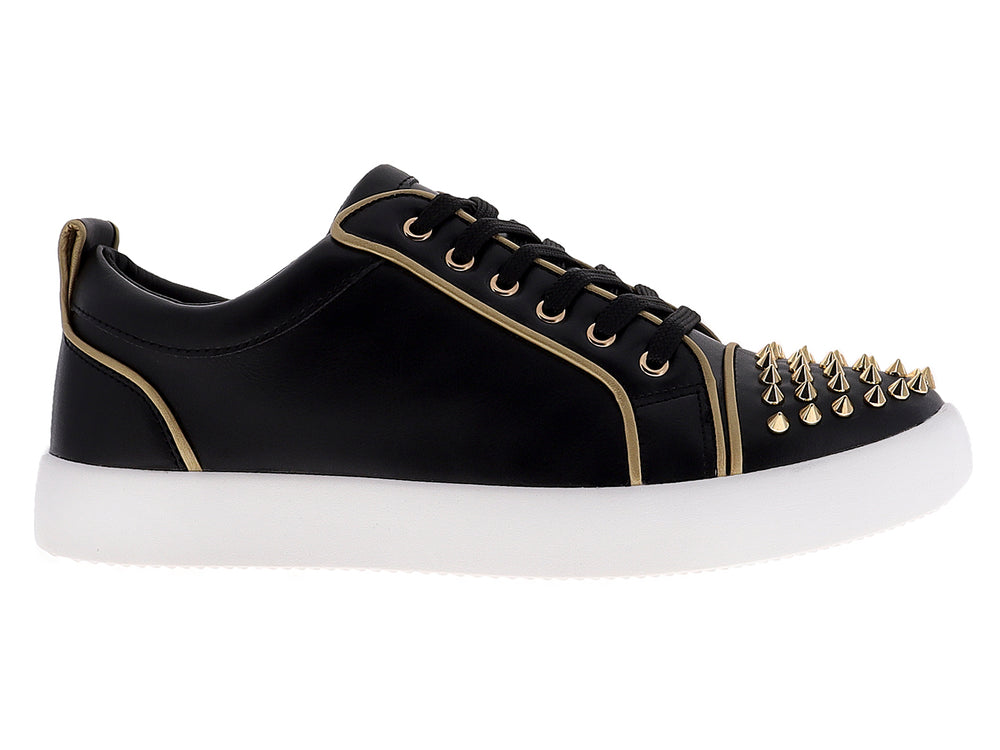 Tenis negros para hombre con tachuelas doradas en la punta y suela blanca.