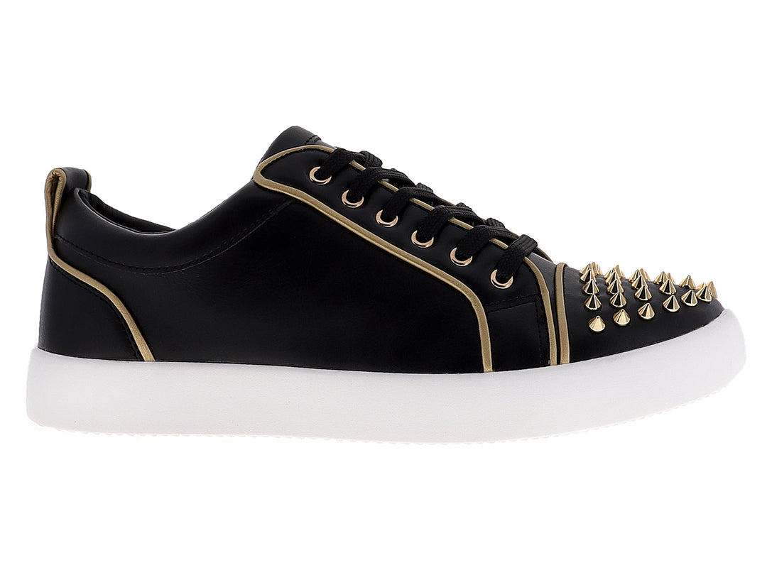 Tenis negros para hombre con tachuelas doradas en la punta y suela blanca.