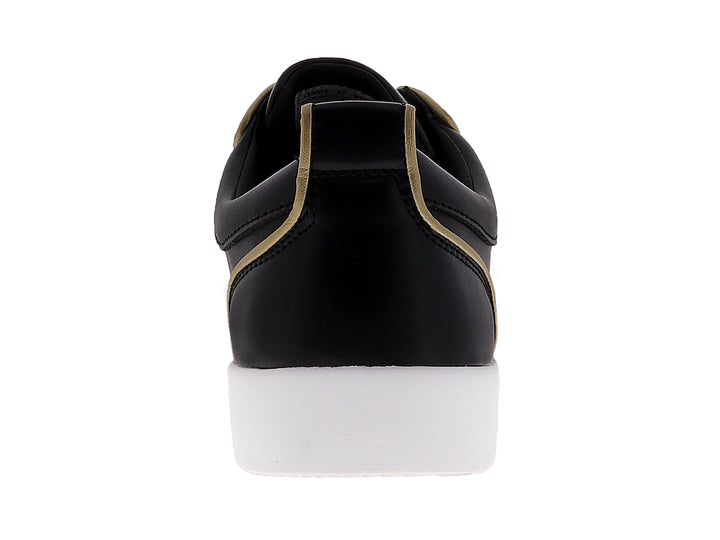 Tenis negros para hombre con tachuelas doradas en la punta y suela blanca.