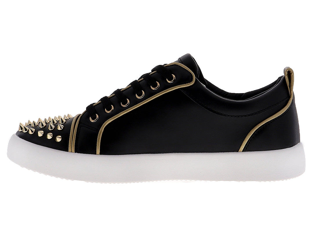 Tenis negros para hombre con tachuelas doradas en la punta y suela blanca.