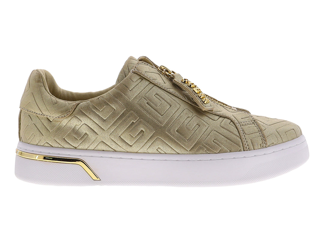 Tenis dorados de la marca GUESS con suela blanca de plataforma y cierre frontal decorativo.