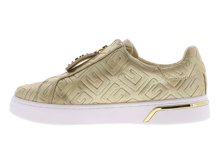 Tenis dorados de la marca GUESS con suela blanca de plataforma y cierre frontal decorativo.