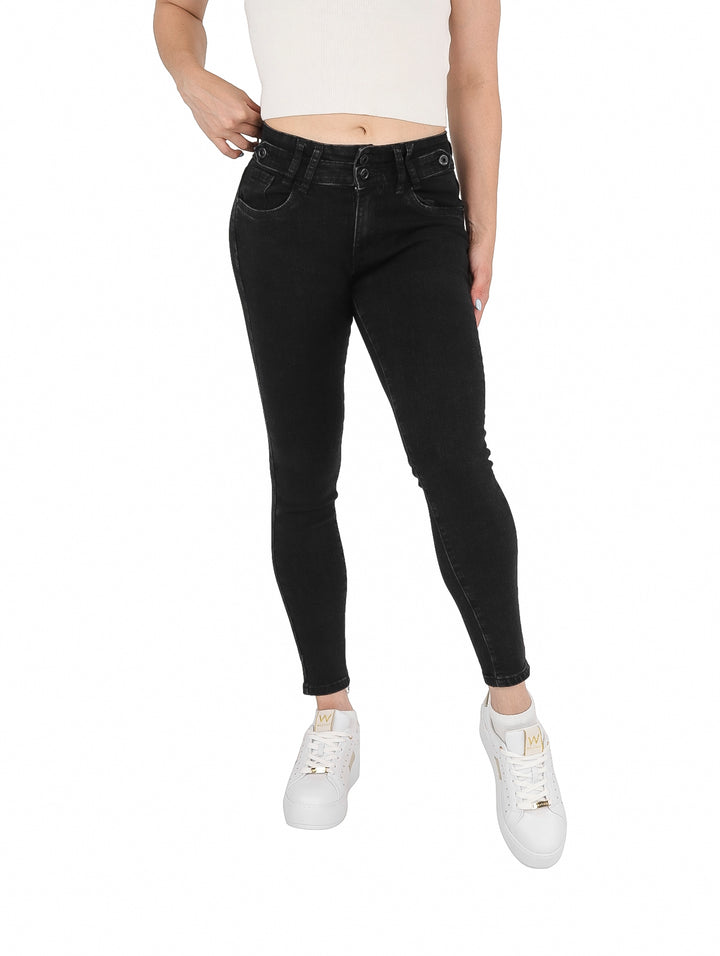 Mujer vistiendo pantalones jeans ajustados de color negro con calzado blanco.