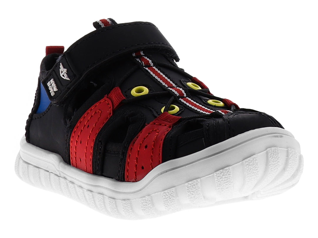 Sandalia infantil cerrada color negro con detalles en rojo y suela blanca.