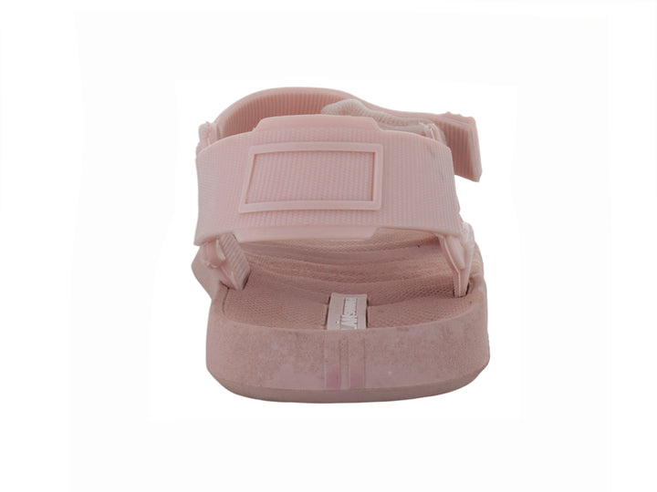 Sandalia color rosa leche con correas ajustables de velcro y suela plana.