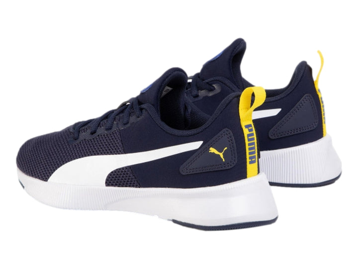 Tenis deportivos PUMA color azul marino con franja y suela blanca y detalles en amarillo.