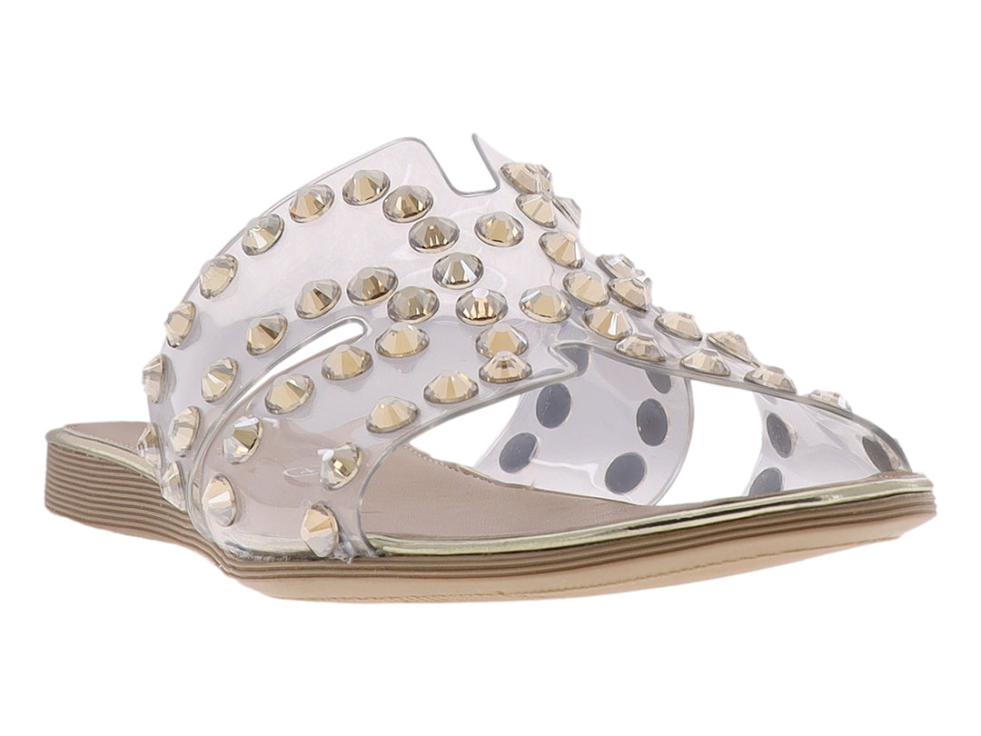 Sandalia con tira transparente y estoperoles dorados sobre suela beige.