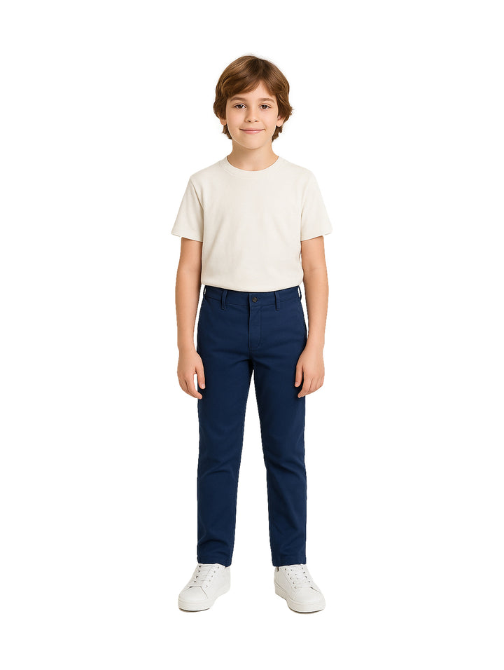 Niño vistiendo pantalón chino de gabardina color azul marino y playera blanca.