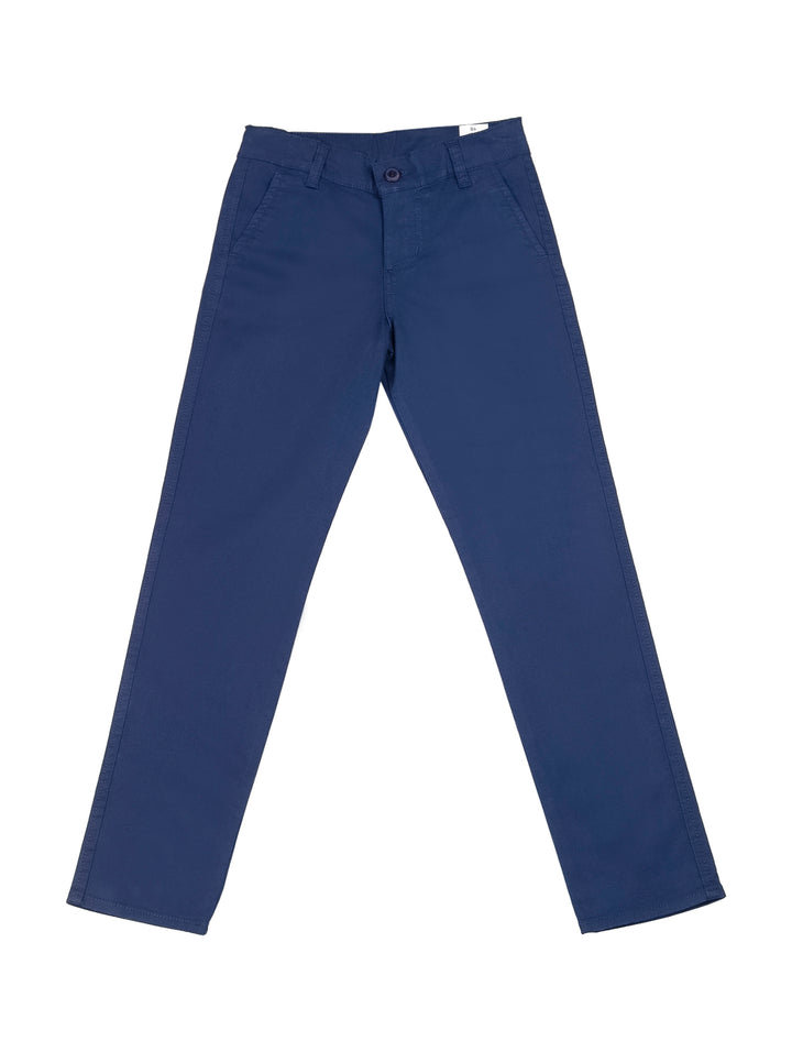 Niño vistiendo pantalón chino de gabardina color azul marino y playera blanca.