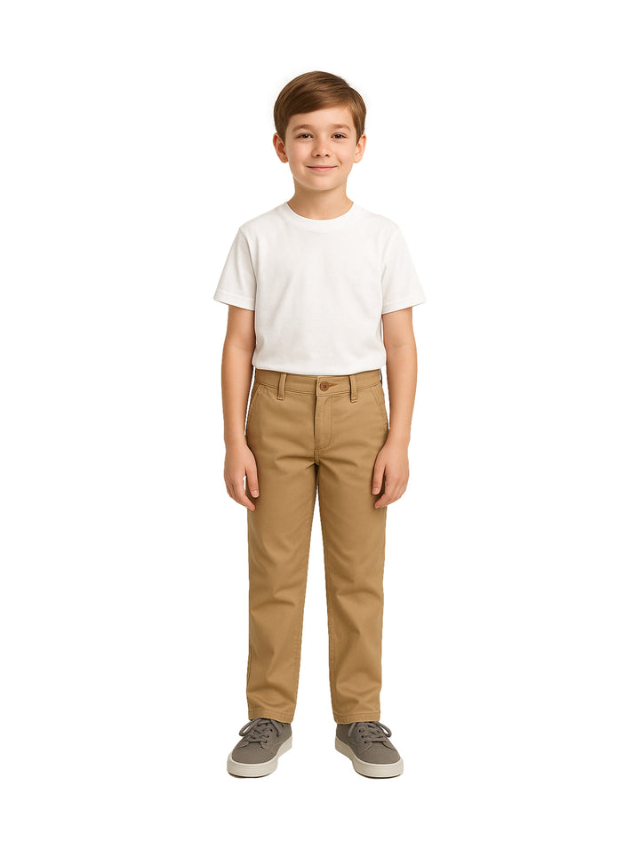 Niño vistiendo pantalón tipo chino de gabardina color beige y camiseta blanca.