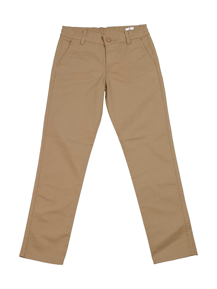 Niño vistiendo pantalón tipo chino de gabardina color beige y camiseta blanca.