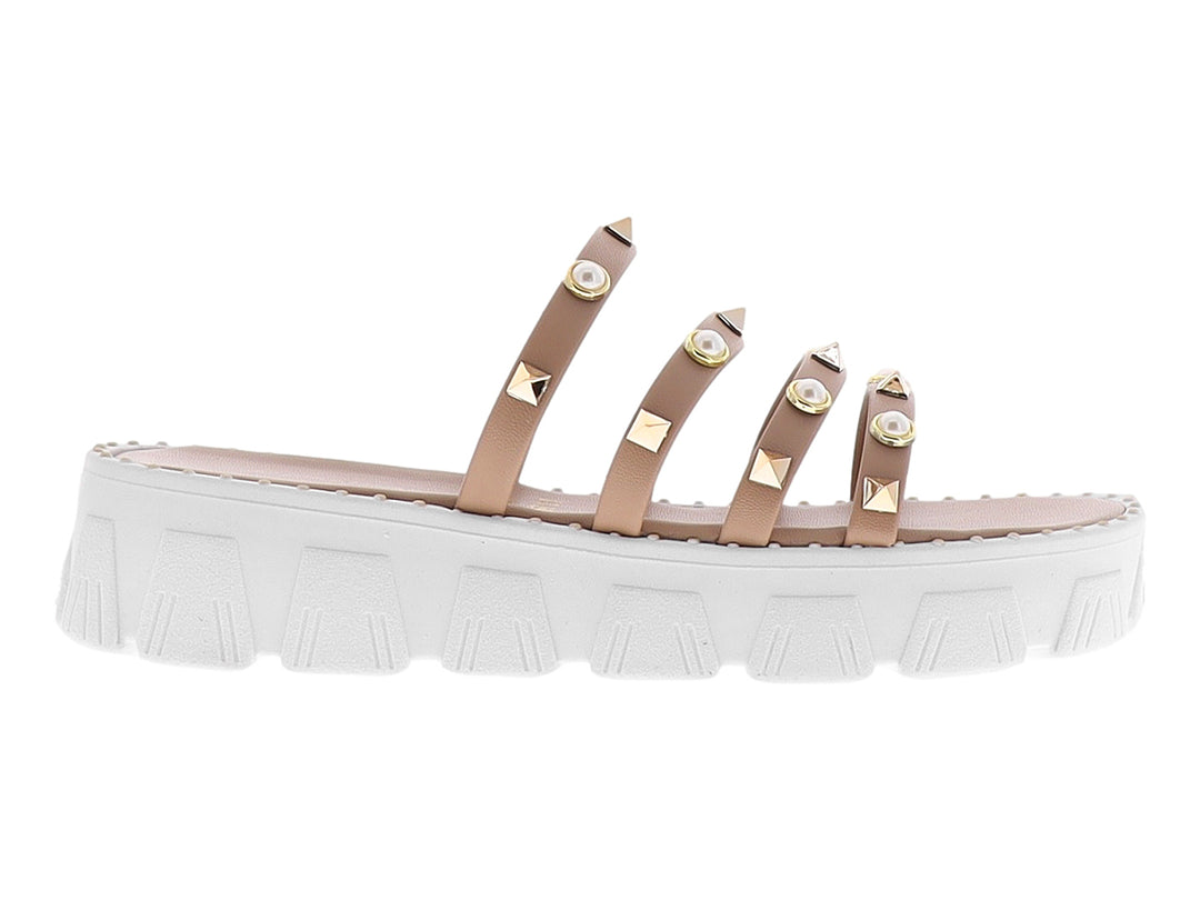 Sandalias de plataforma color maquillaje con tiras adornadas con perlas y tachuelas doradas sobre suela blanca.