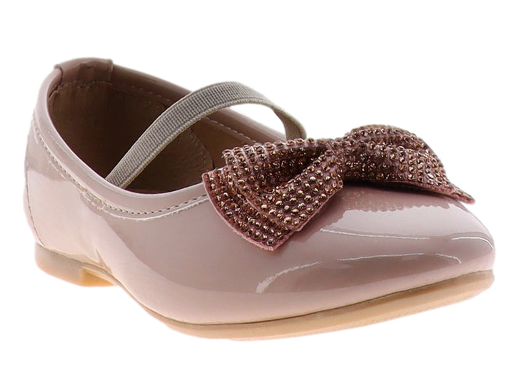 Zapato plano color maquillaje en charol brillante con un moño decorado con pedrería y correa ajustable.