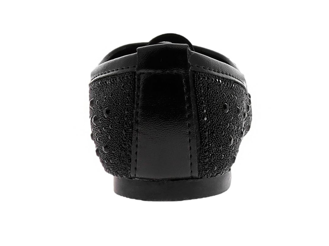 Zapato plano negro para niña con textura punteada y correa elástica superior.