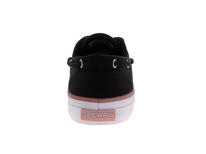 Zapato náutico Sperry de tela negra con franja rosa y suela blanca.