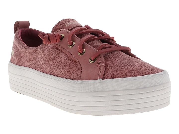 Tenis Sperry color rosa con textura de piel de serpiente y suela de plataforma blanca.