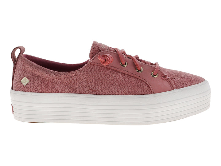 Tenis Sperry color rosa con textura de piel de serpiente y suela de plataforma blanca.