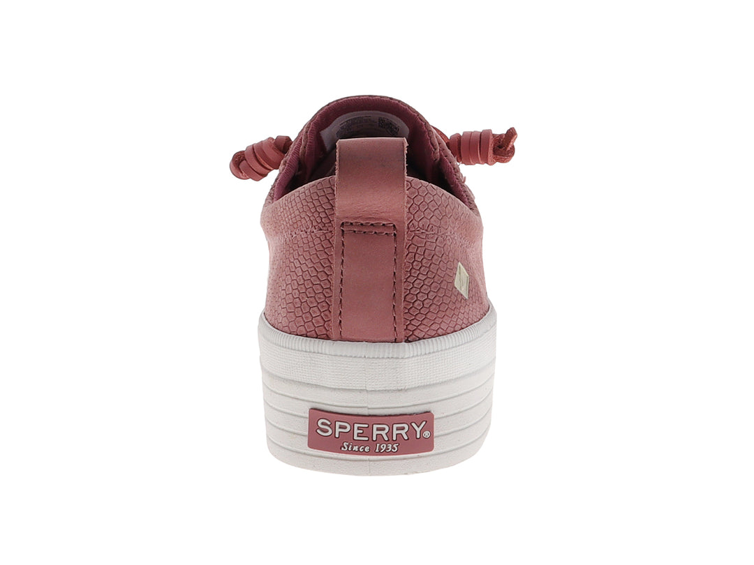 Tenis Sperry color rosa con textura de piel de serpiente y suela de plataforma blanca.