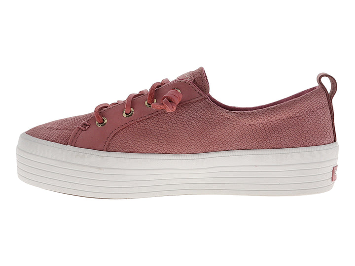 Tenis Sperry color rosa con textura de piel de serpiente y suela de plataforma blanca.