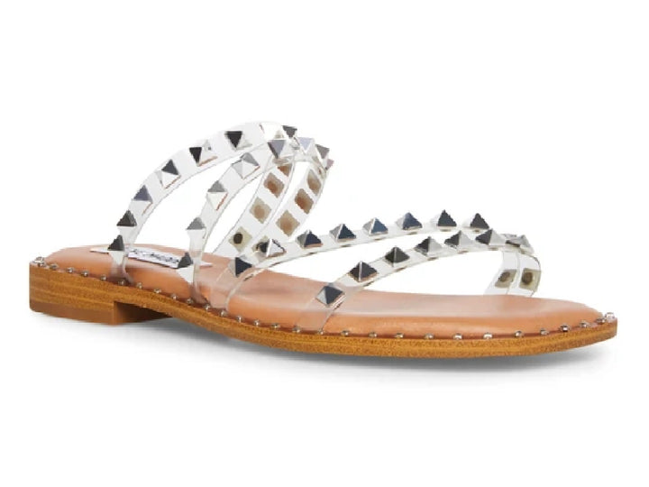Sandalias planas con tiras transparentes y estoperoles plateados sobre suela color café.