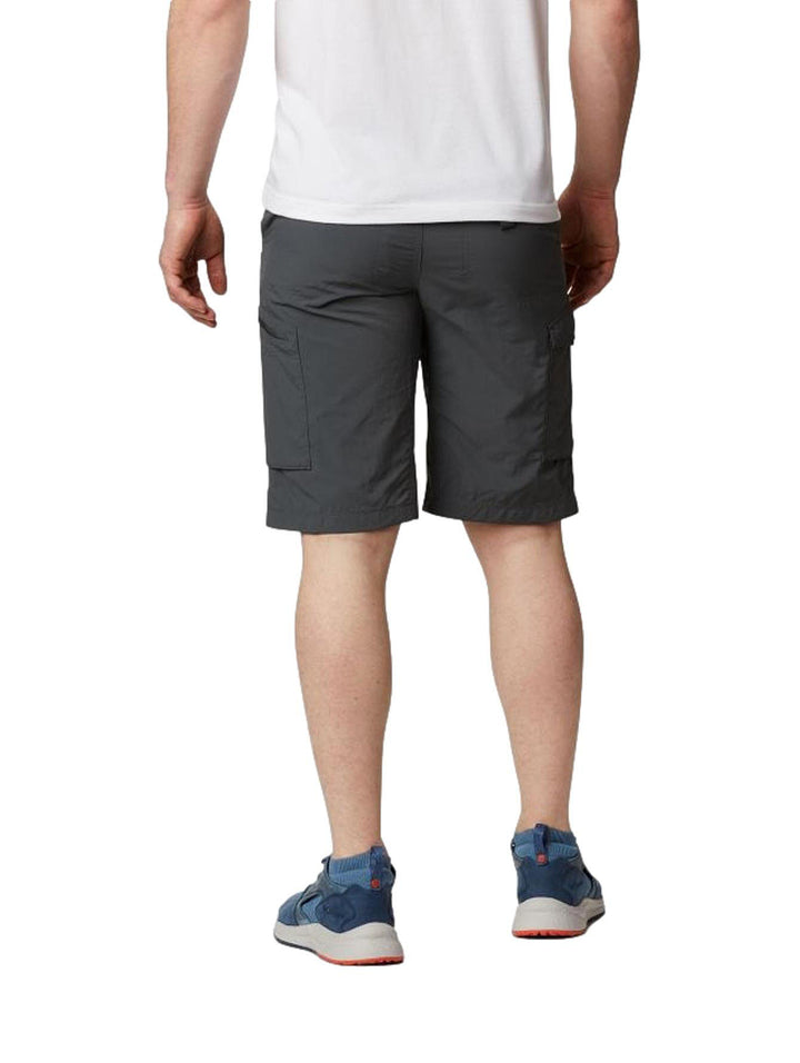 Hombre vistiendo pantalones cortos tipo cargo color gris marca Columbia con bolsillos laterales.