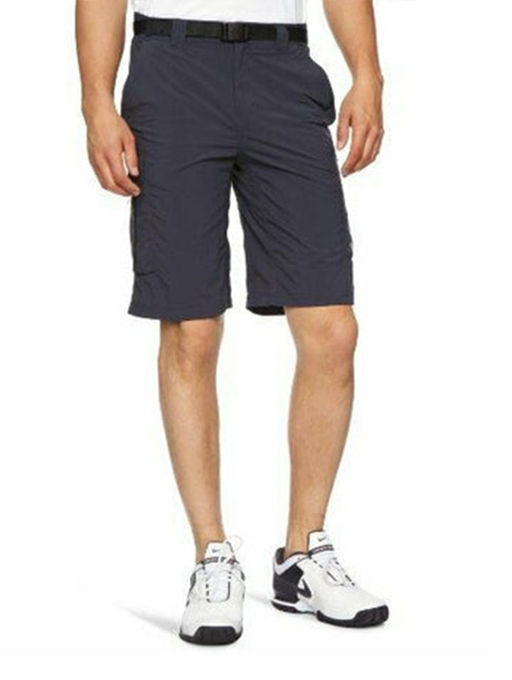 Hombre vistiendo shorts cargo Columbia color azul marino con cinturón negro y tenis blancos.
