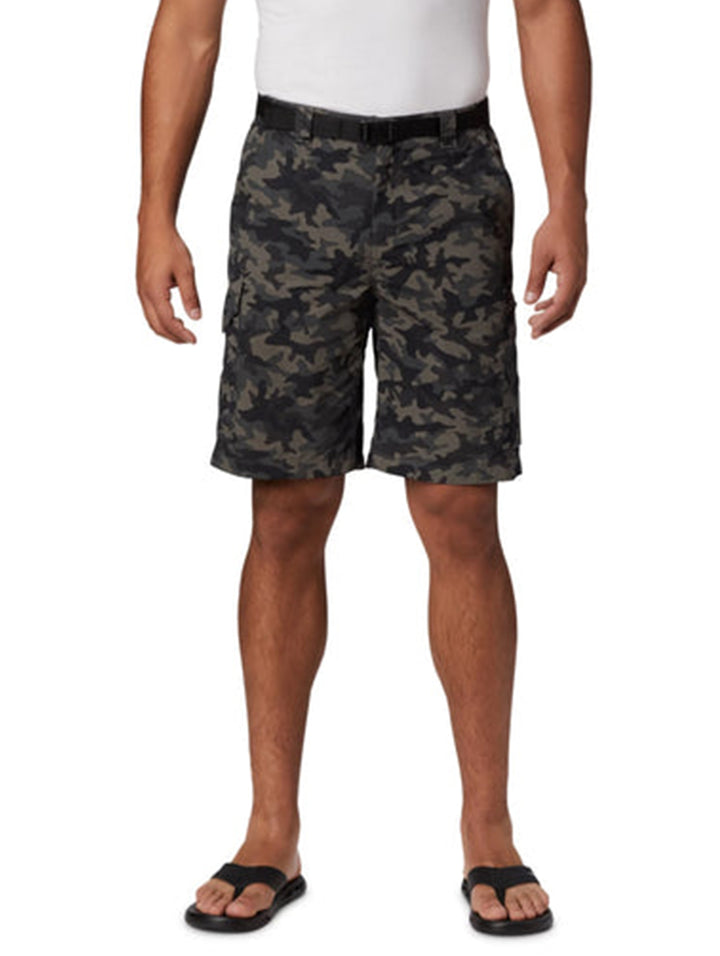 Hombre vistiendo shorts tipo cargo Columbia con estampado de camuflaje en tonos negro y gris.