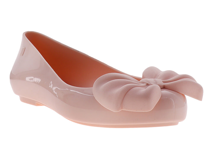 Zapato plano color rosa con un moño decorativo en la parte frontal y acabado brillante.