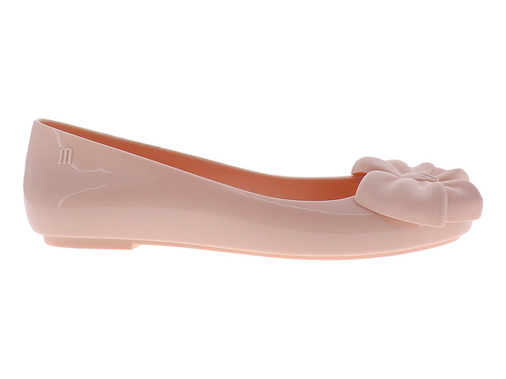 Zapato plano color rosa con un moño decorativo en la parte frontal y acabado brillante.