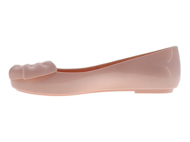 Zapato plano color rosa con un moño decorativo en la parte frontal y acabado brillante.